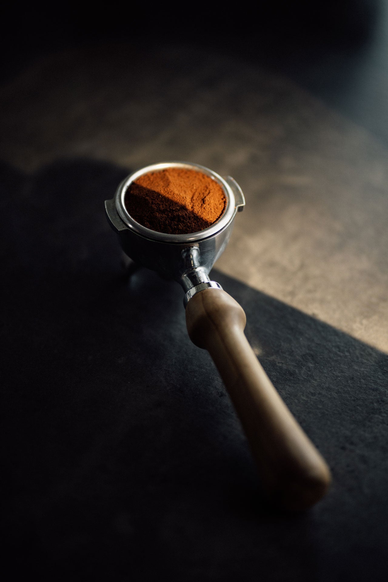 KAffeemehl in einem Siebträger mit Olivenholzgriff