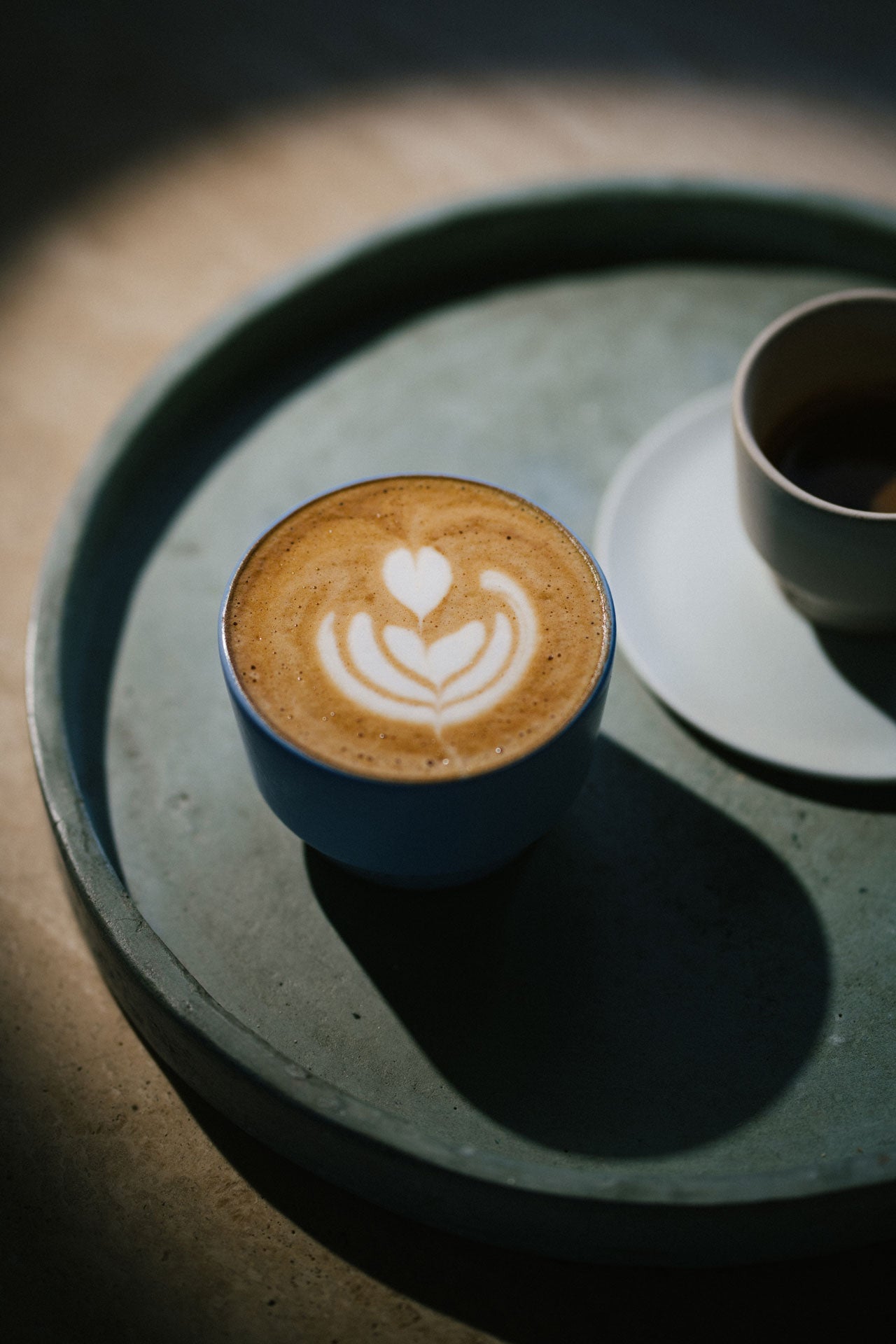 Cappuccinio in einer hellblauen Tasse auf einer runden Unterlage