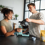 Zwei Menschen trinken einen Kaffee von Mocino aus einer türkisen Moccamaster 